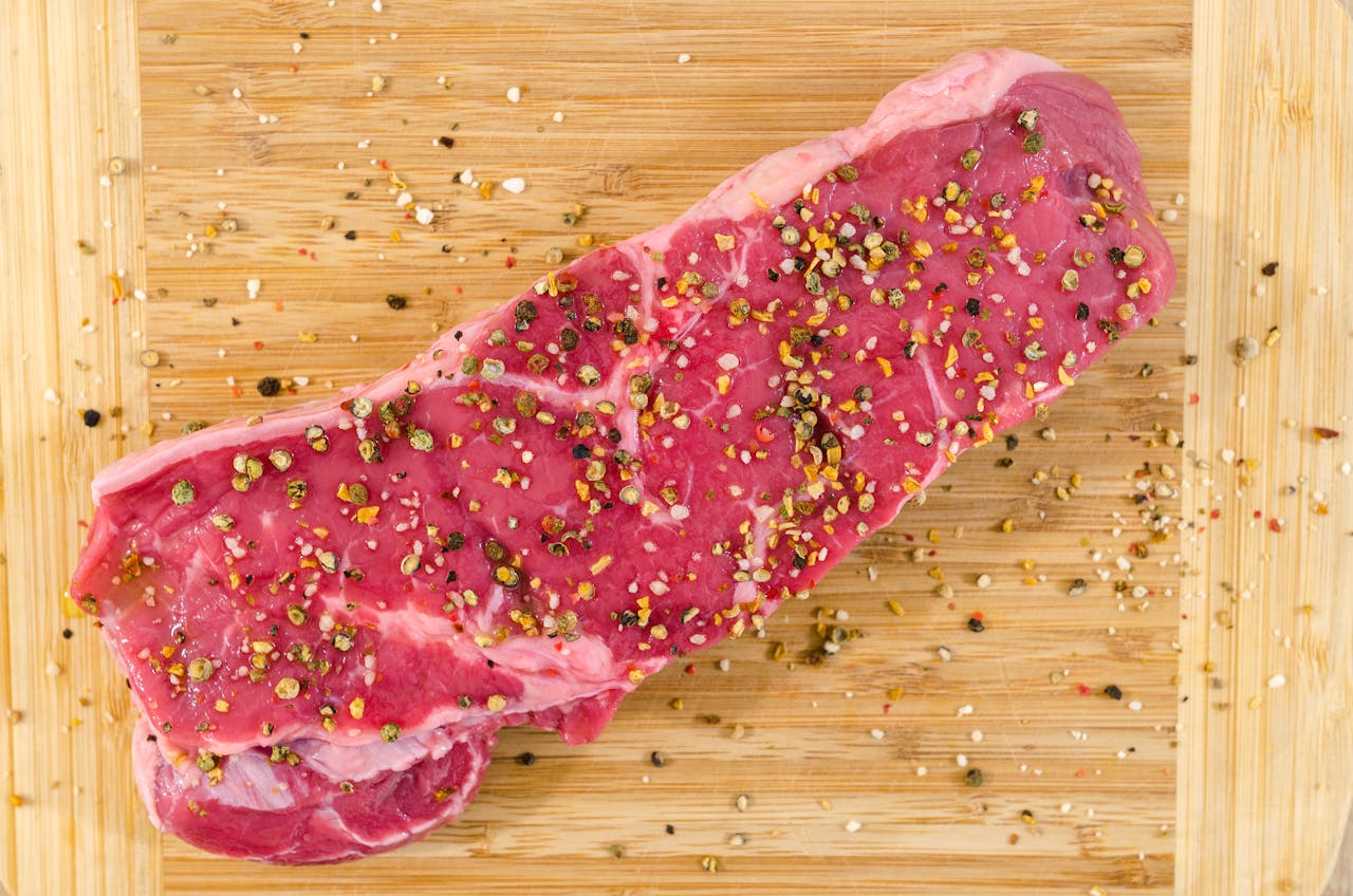 The Art of Drawing Readers In: Your attractive post title goes here Close-up of a raw steak with spices on a wooden cutting board, perfect for cooking inspirations.